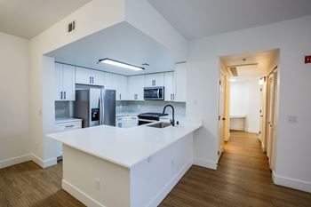 A kitchen with white countertops and stainless steel appliances.